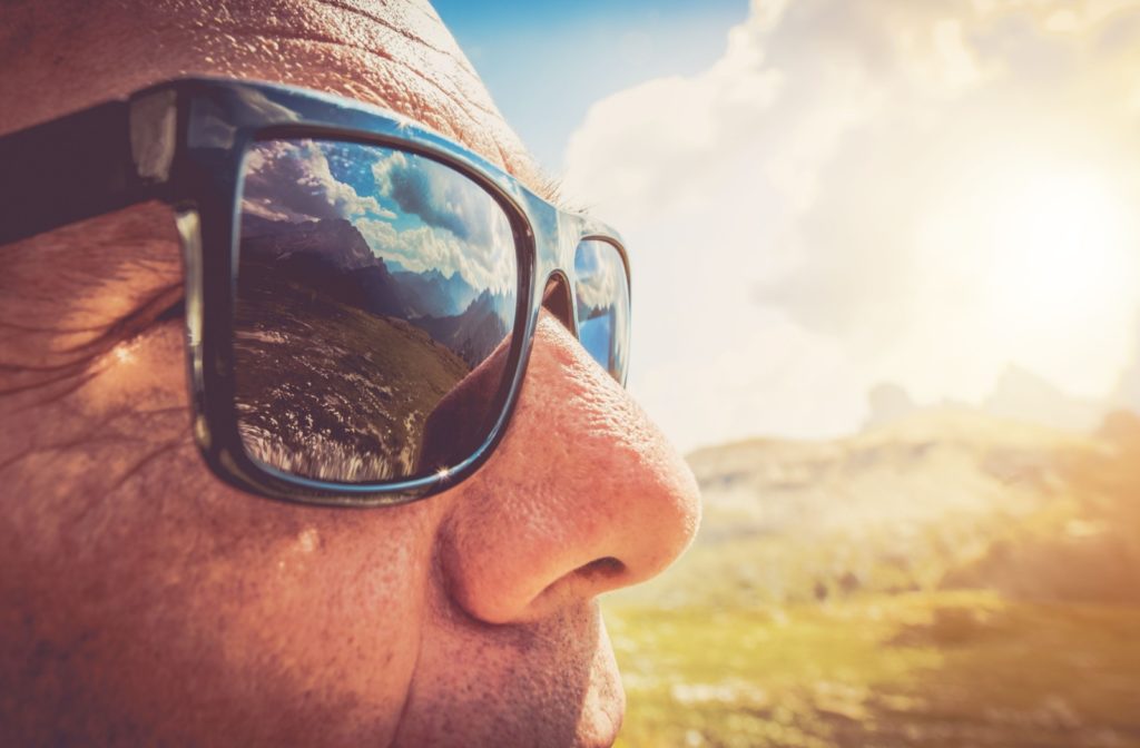 A close up shot of sunglasses protecting a man's eye's from the sun.