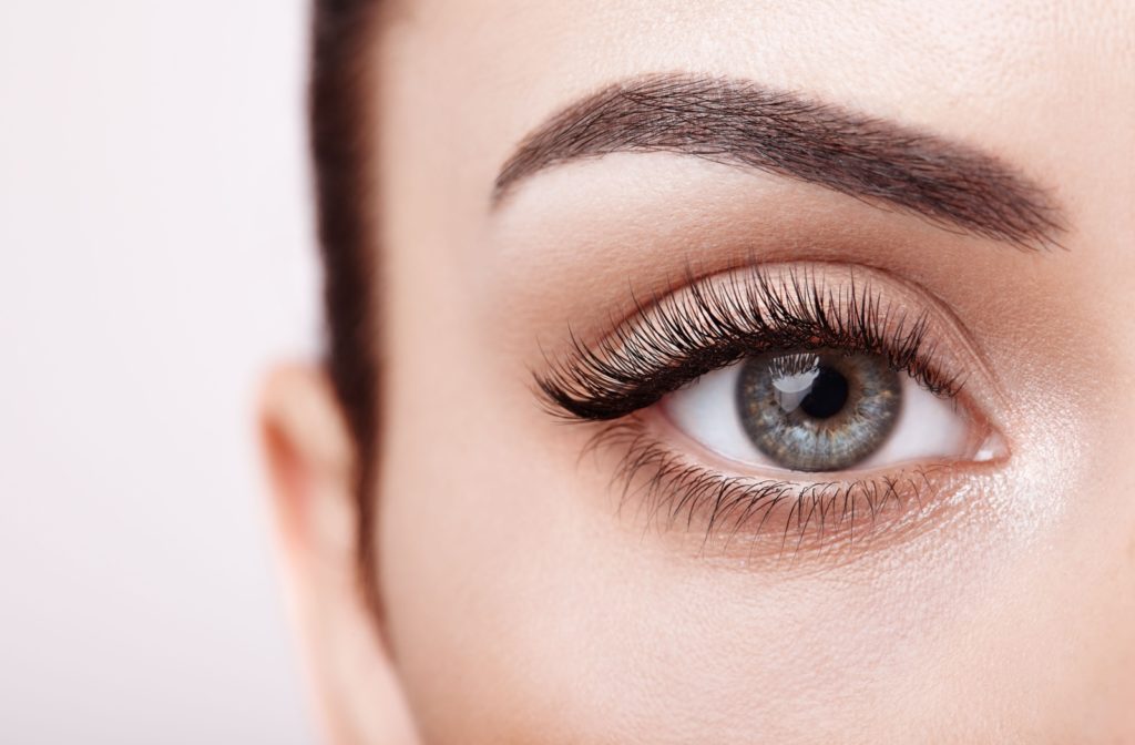 A close-up image of a woman's right eye with eyelash extensions.