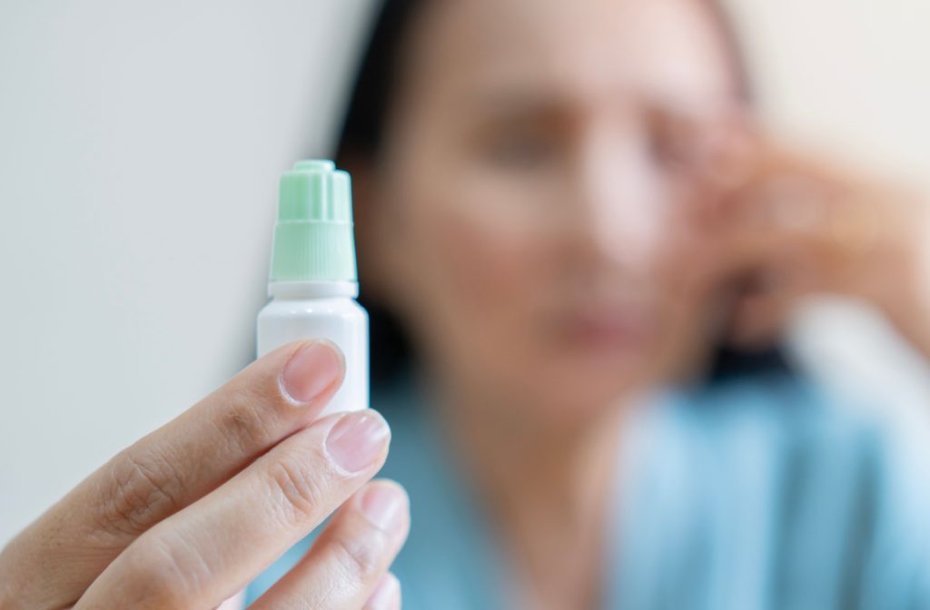 A close up of someone holding a bottle of atropine eye drops