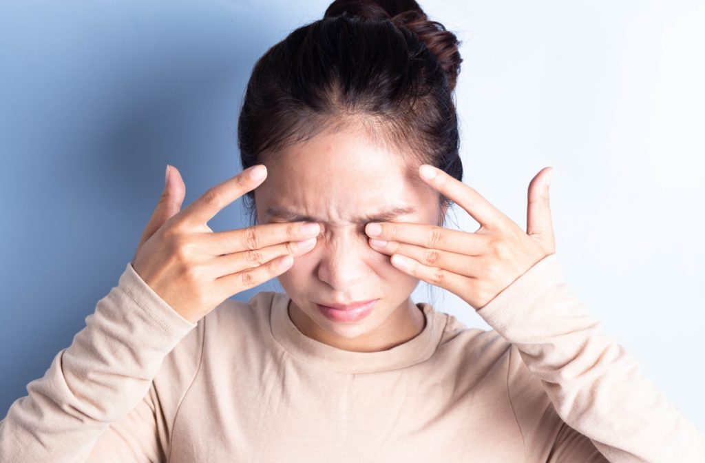 A close up image of a person rubbing their irritated eyes for relief.