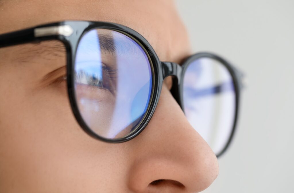 A close up of a person wearing eyeglasses that are too strong.