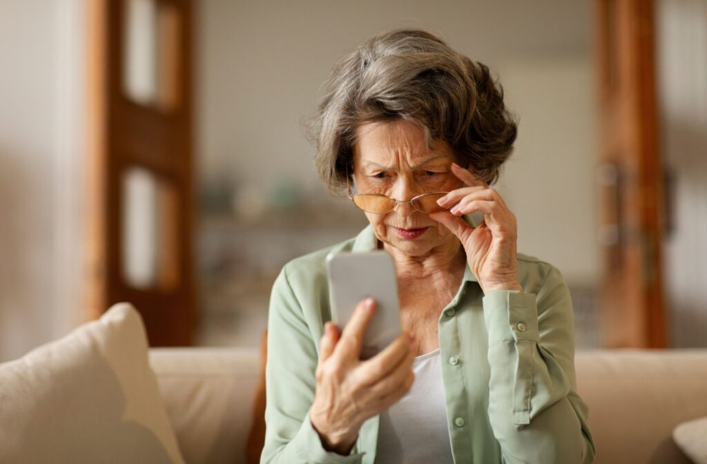 An adult with presbyopia struggling to see what is on their phone screen.